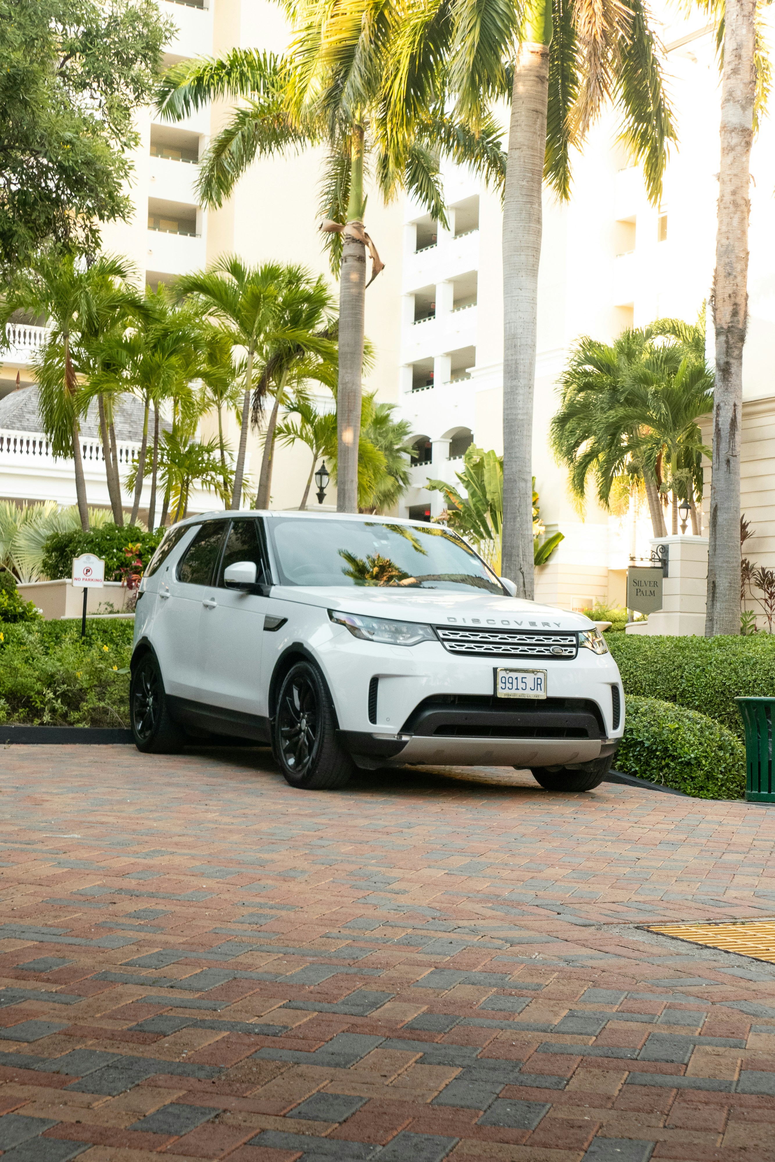 a white range rover parked in front of a hotel