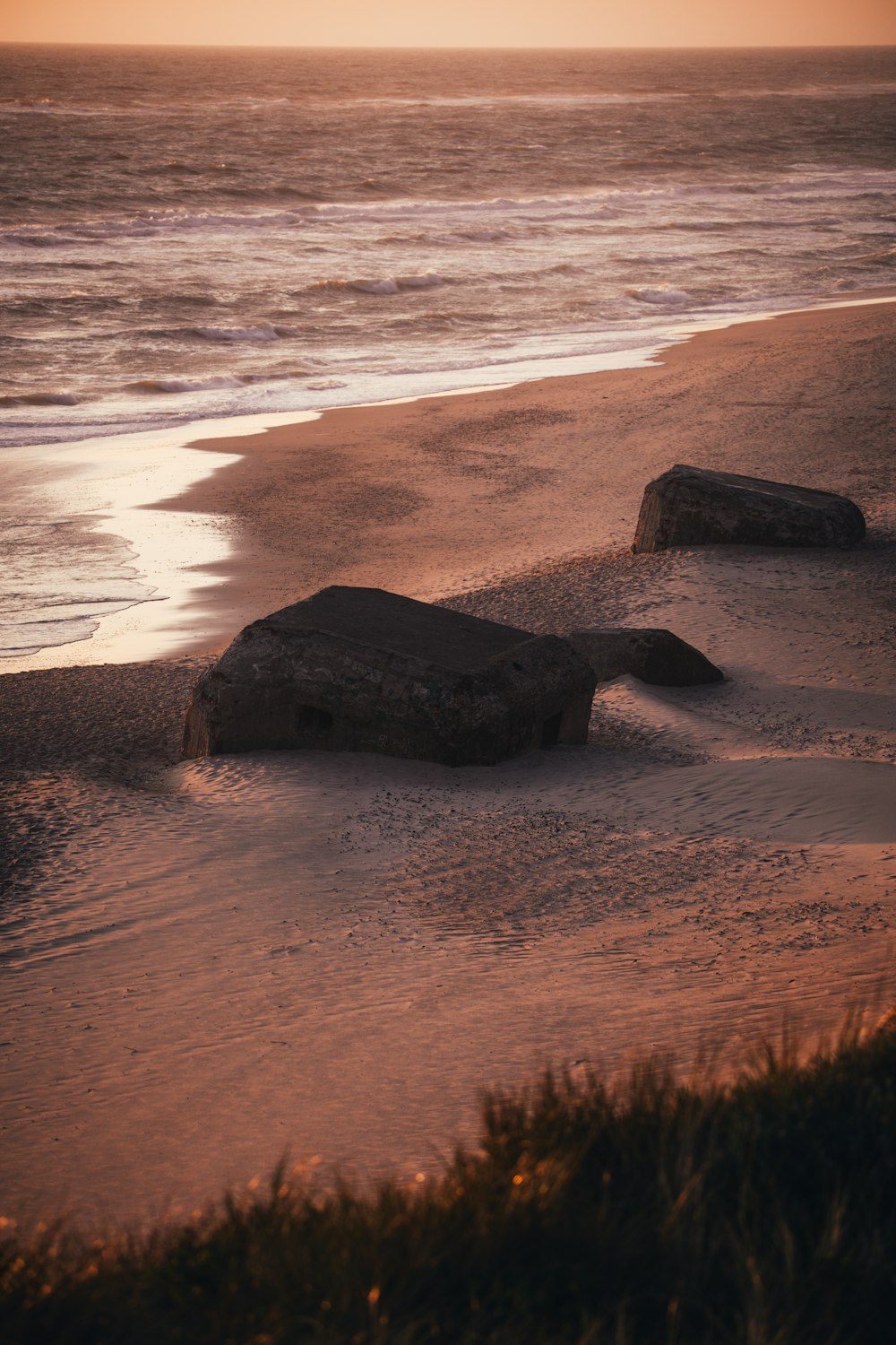 모래 사장 위에 앉아있는 두 개의 큰 바위
