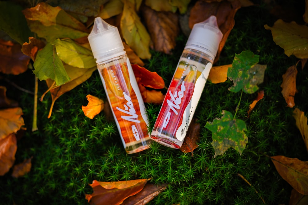 a couple of bottles sitting on top of a lush green field