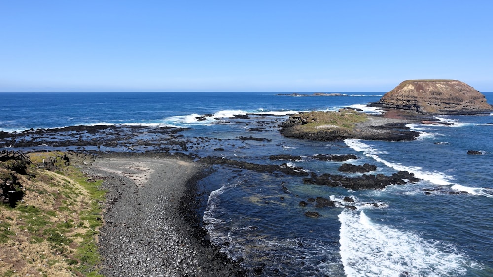 a view of a rocky beach with waves crashing on the shore