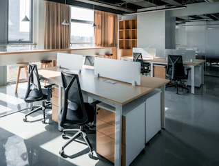 an office with a desk and chairs and a window