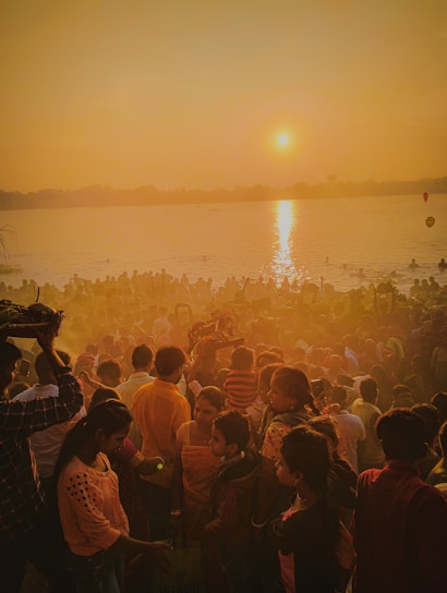 A serene image of devotees gathered at Triveni Sangam during sunset.