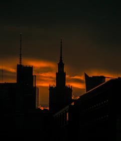 the sun is setting over a city with tall buildings