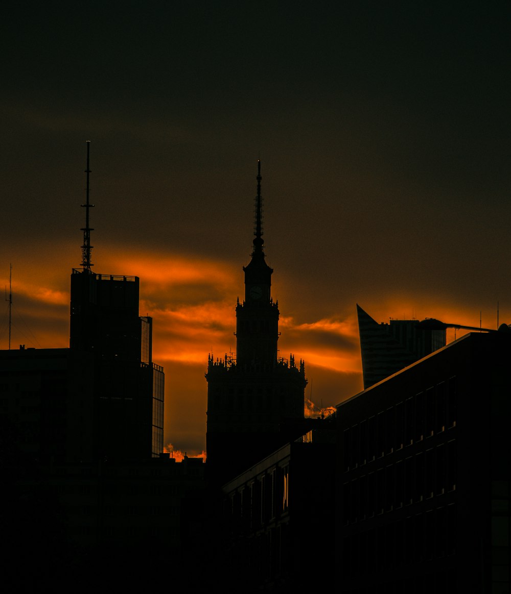 the sun is setting over a city with tall buildings