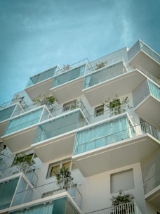 a tall building with balconies and plants on the balconies