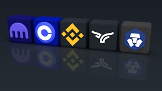 A row of five 3D cubes featuring different cryptocurrency exchange logos arranged side by side on a reflective surface. The cubes are colored in various shades of blue, black, and yellow with distinct brand symbols on each.