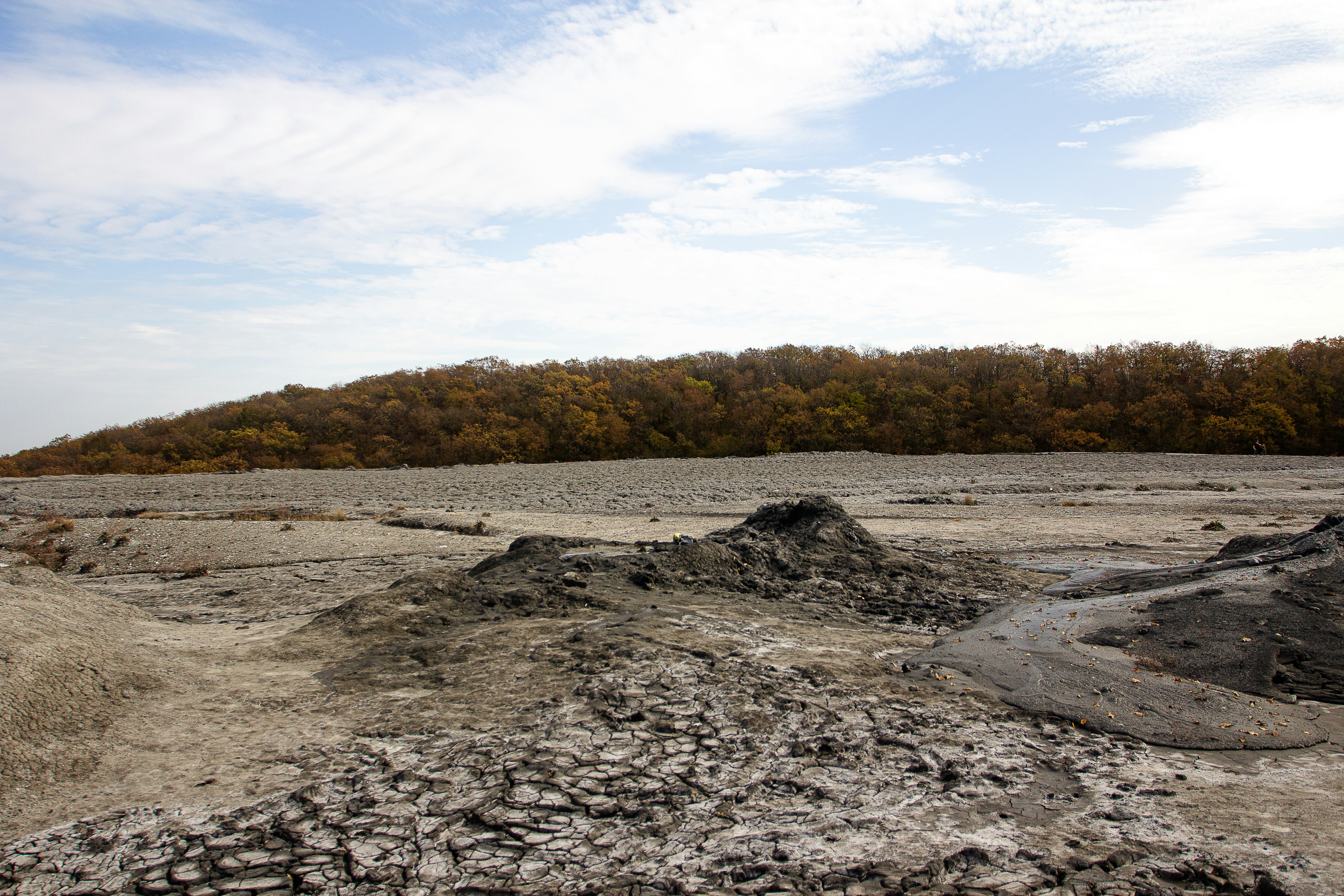 a dirt field with a hill in the background