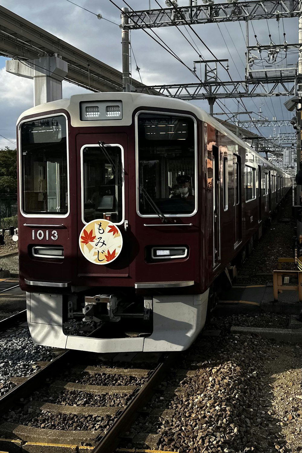 a red and white train traveling down train tracks