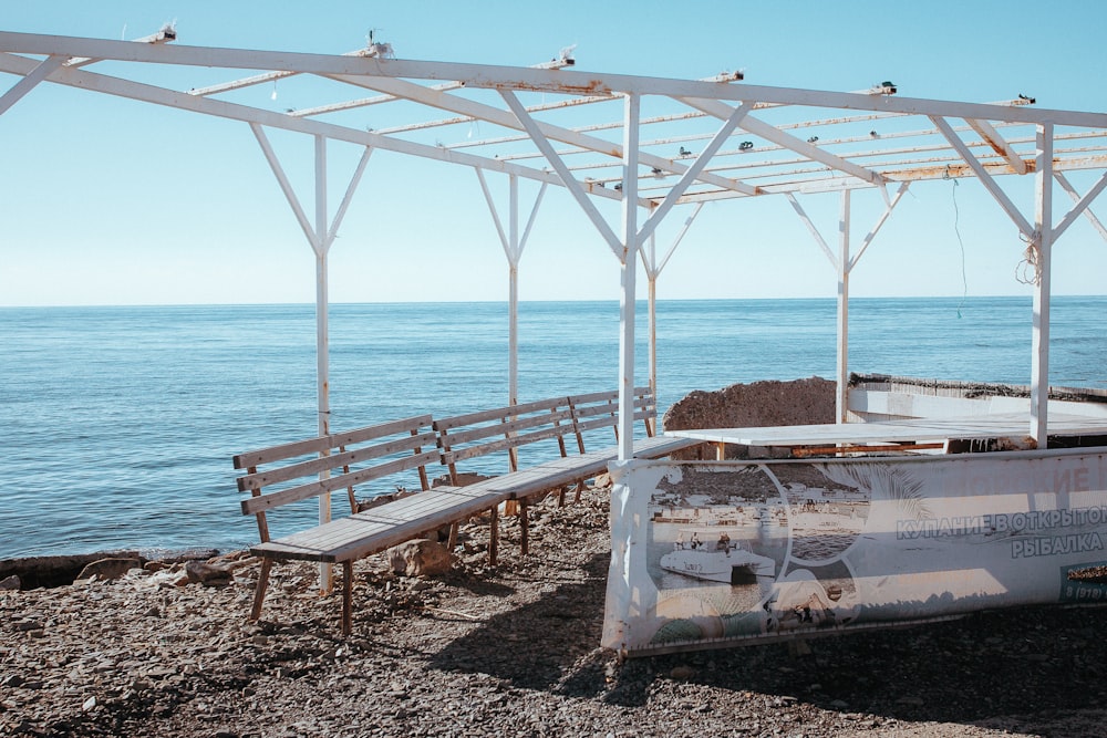 a wooden bench sitting next to the ocean