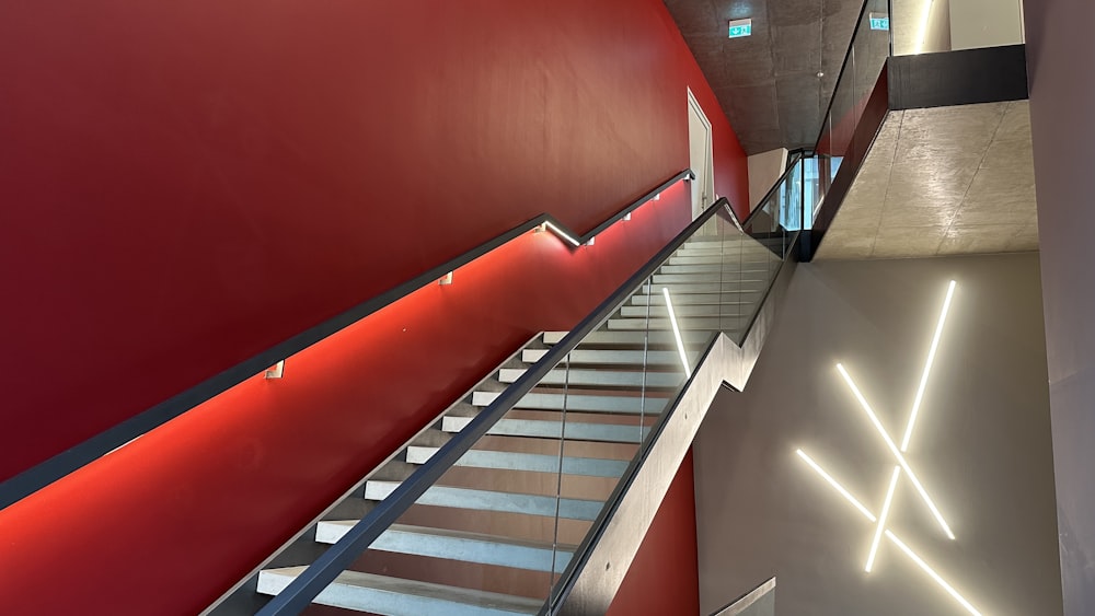 a red wall with a stair case next to it