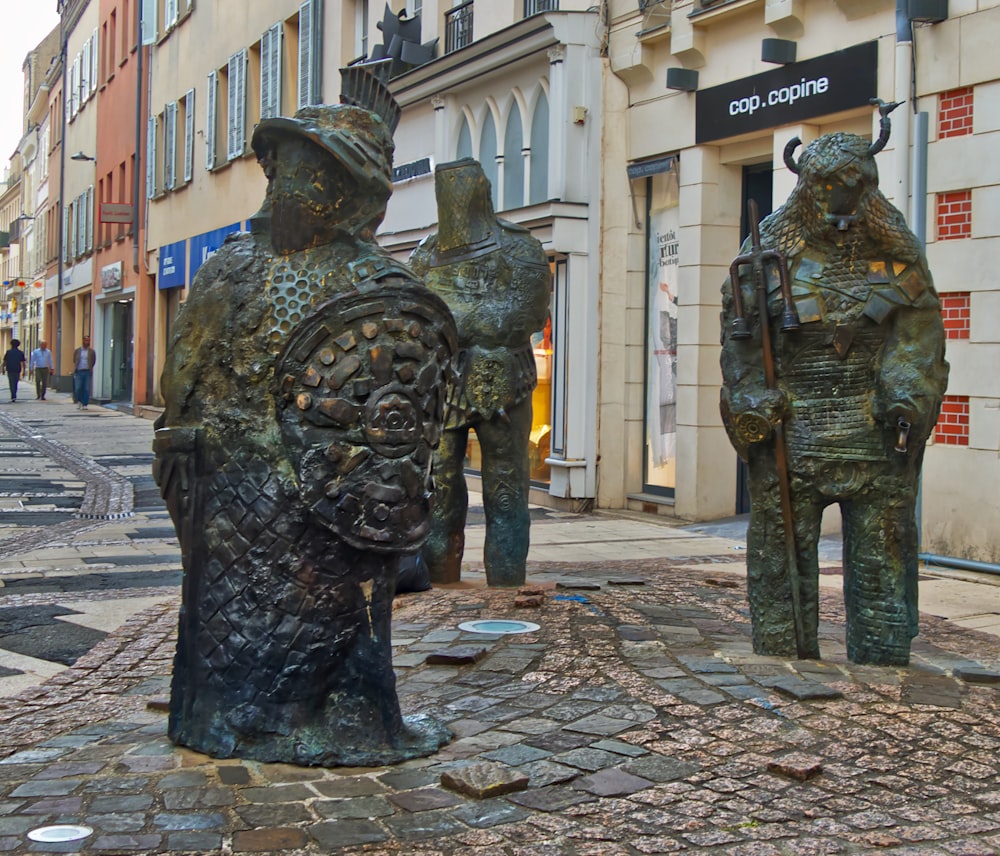 a couple of statues that are on the side of a road