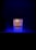A lit candle with a label that reads 'Only For You, Handmade Candle, Aromatherapy Experts' is placed against a dark background. The candle emits a soft, warm glow surrounded by a subtle blue mist or smoke.