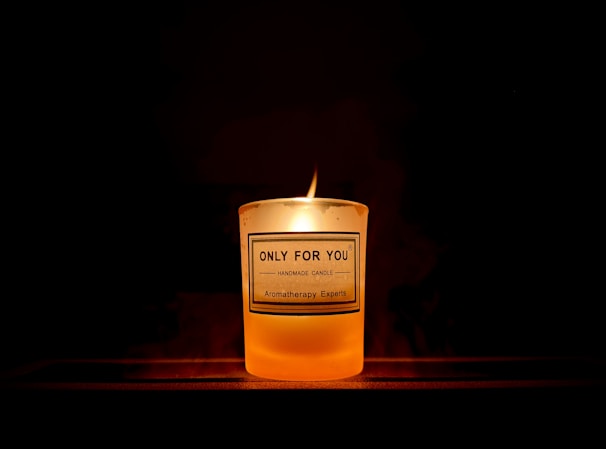A glowing candle with a custom label featuring Isaiah 40:31 scripture, surrounded by soft natural light.