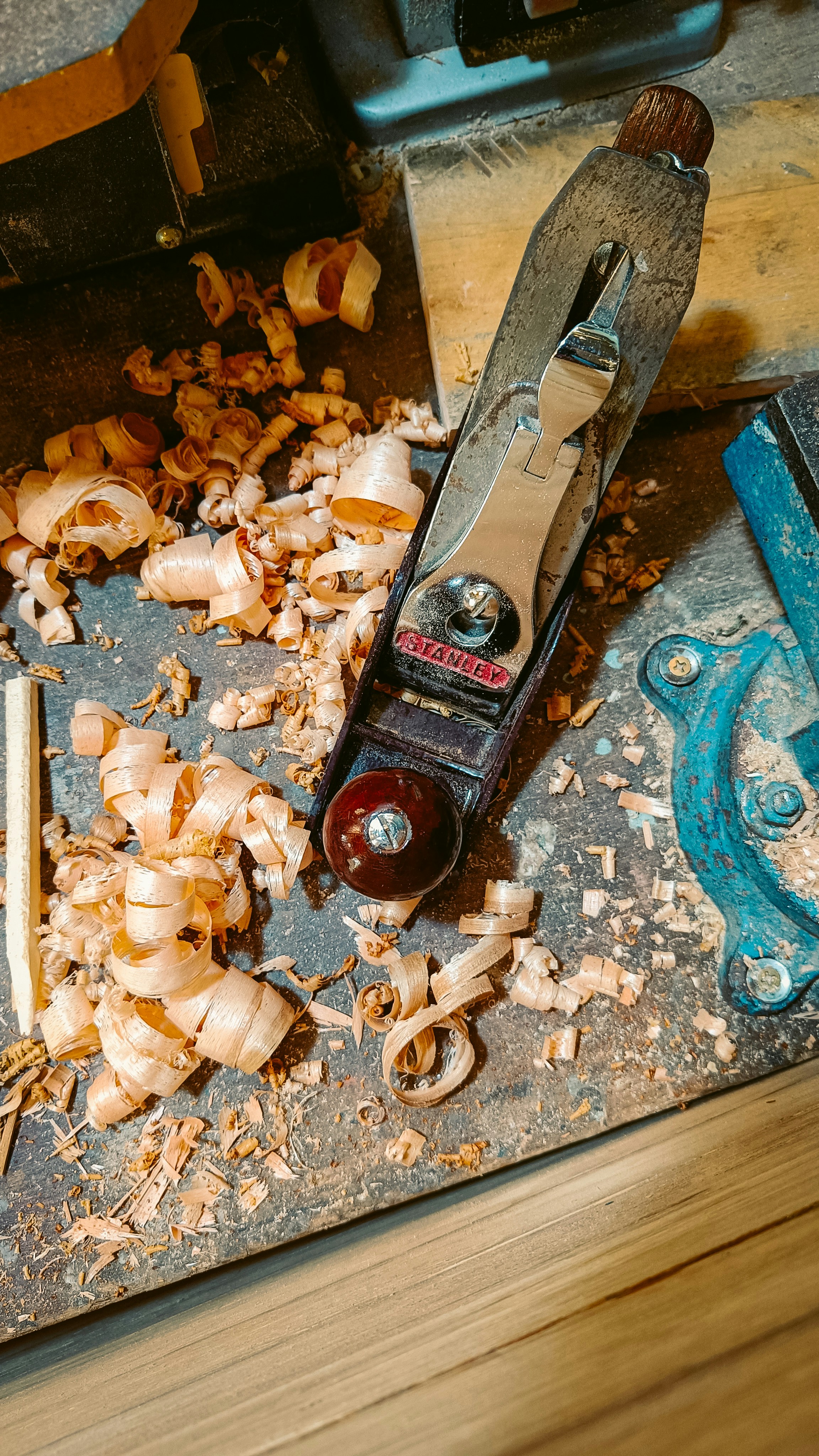 a pair of scissors and some wood shavings on a table