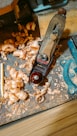 a pair of scissors and some wood shavings on a table