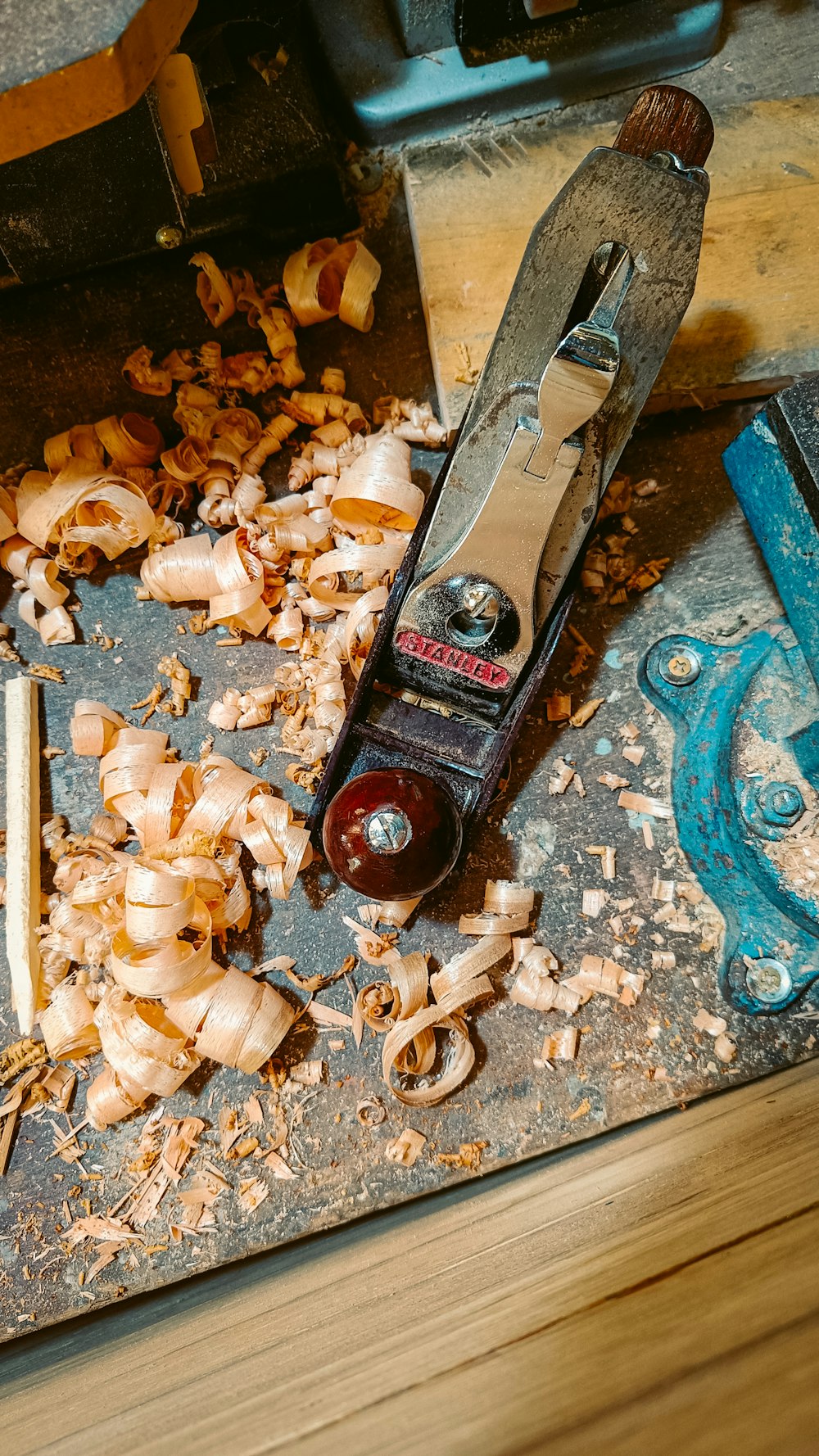 a pair of scissors and some wood shavings on a table