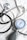 A stethoscope and a sphygmomanometer are laid out on a white fabric surface. The stethoscope has a shiny metallic diaphragm and black tubing. The sphygmomanometer features a round gauge with blue, red, and black markings indicating blood pressure measurements, attached to a gray and black bulb used for inflating the cuff.