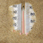 a close up of a thermometer in the sand