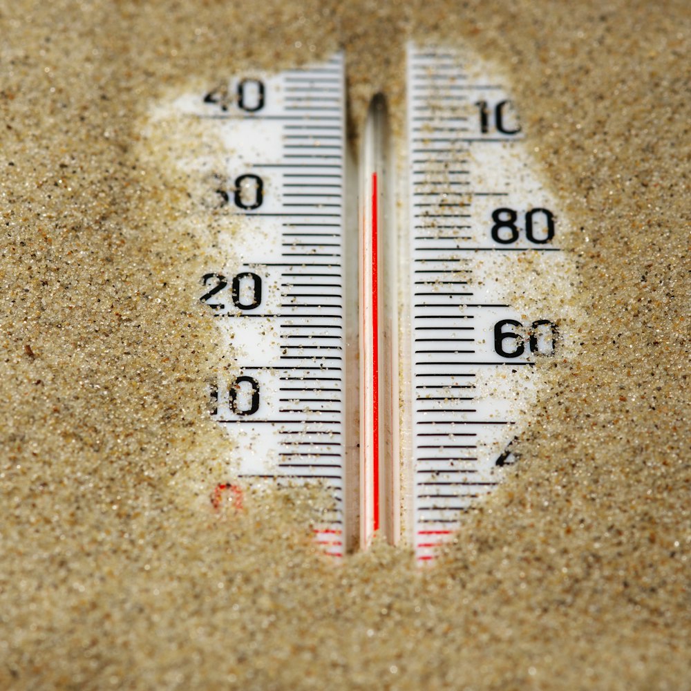 Un primer plano de un termómetro en la arena