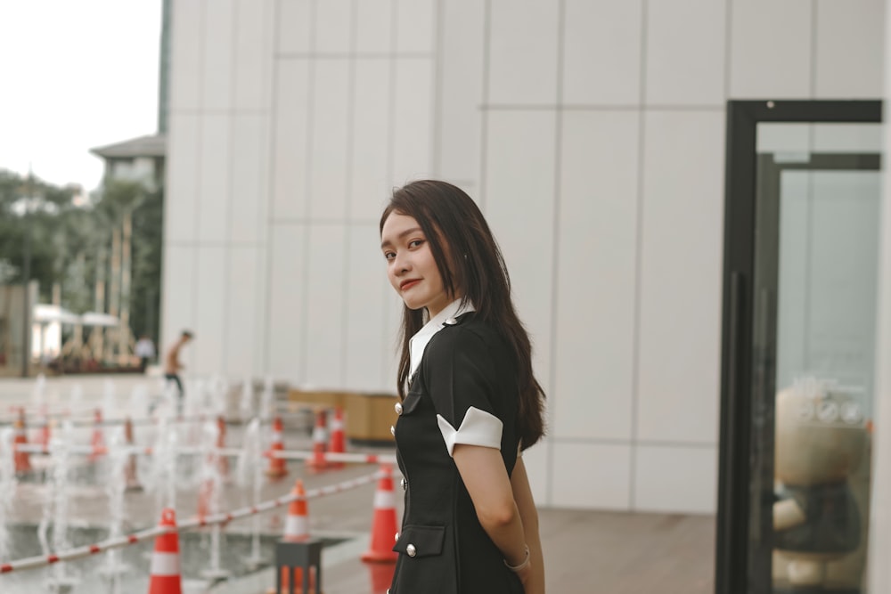 a woman standing in front of a water fountain