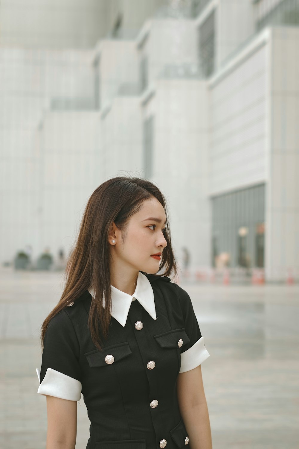 a woman in a black and white uniform standing in front of a building