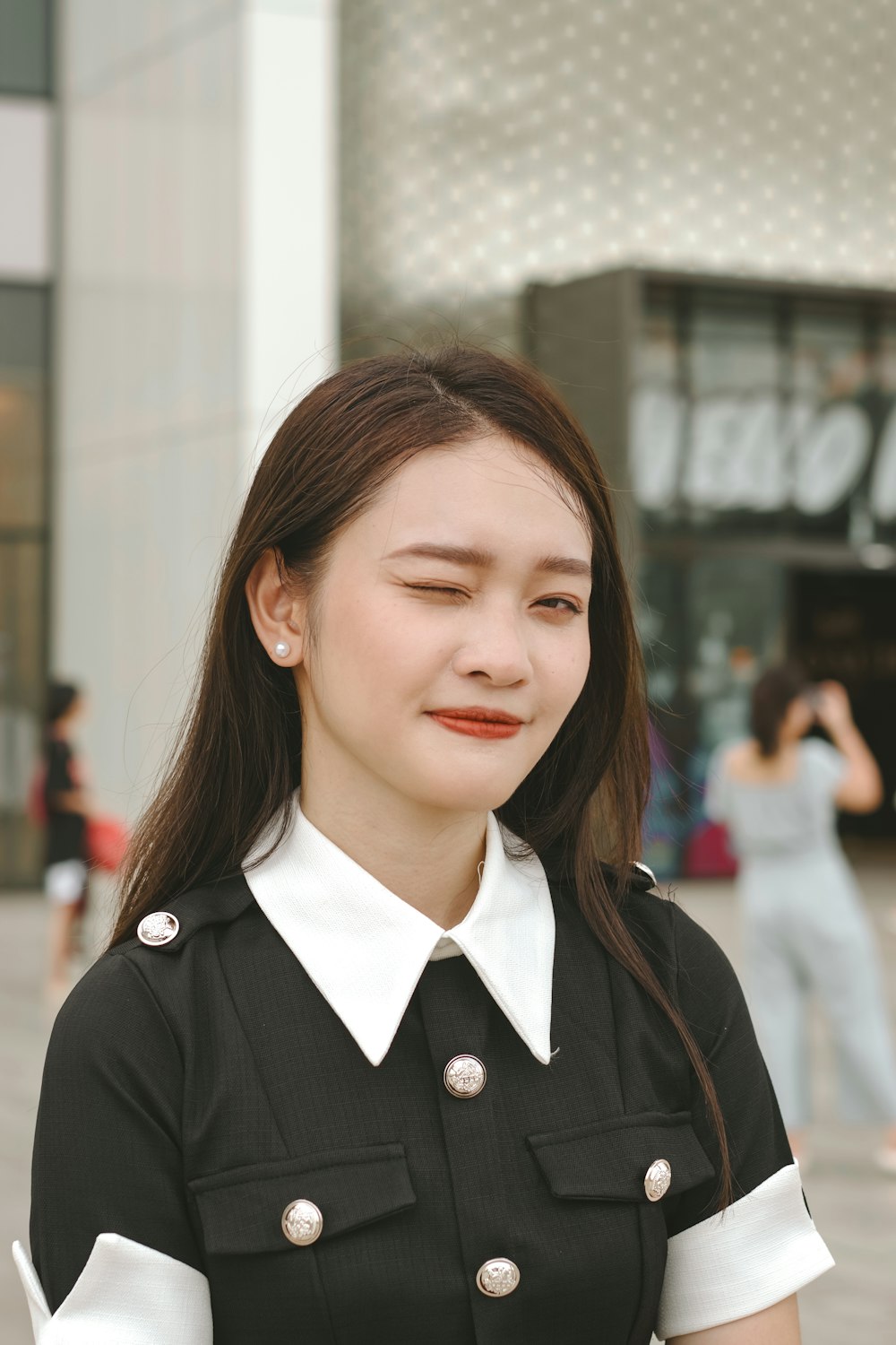 a woman in a black and white dress is smiling