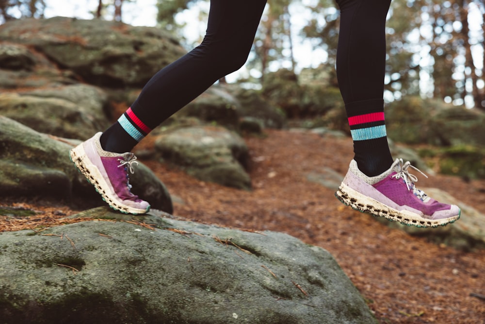 a person walking on a rock in the woods