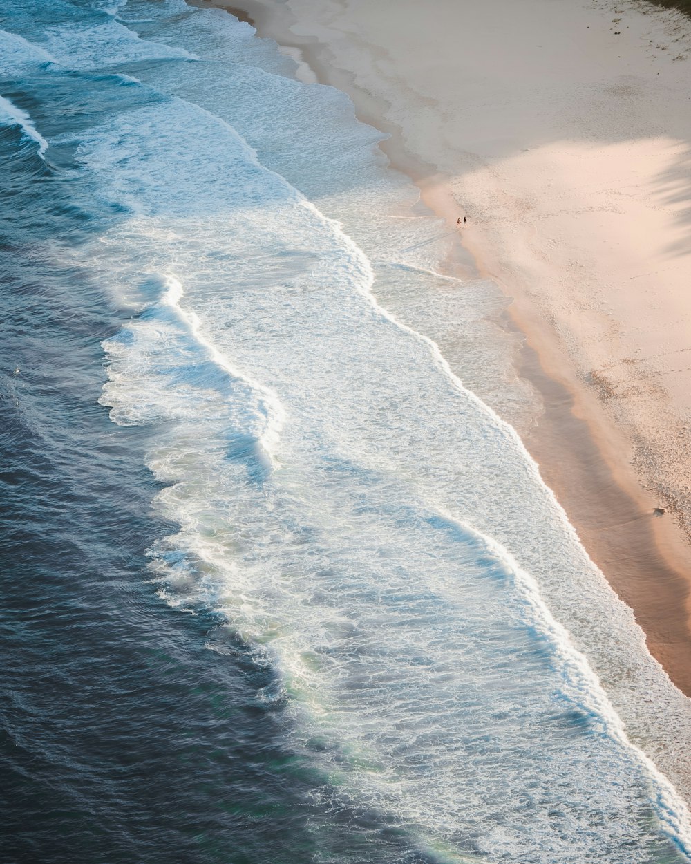 uma vista aérea de uma praia de areia e oceano