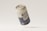 A weathered aluminum can labeled 'WATER DROPS' appears to be floating against a neutral background. The surface of the can is speckled with dirt, giving it a rustic and aged appearance.