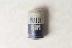 a can of water drops on a white surface