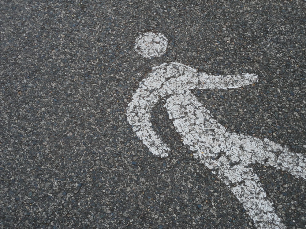 a pedestrian crossing sign painted on the asphalt