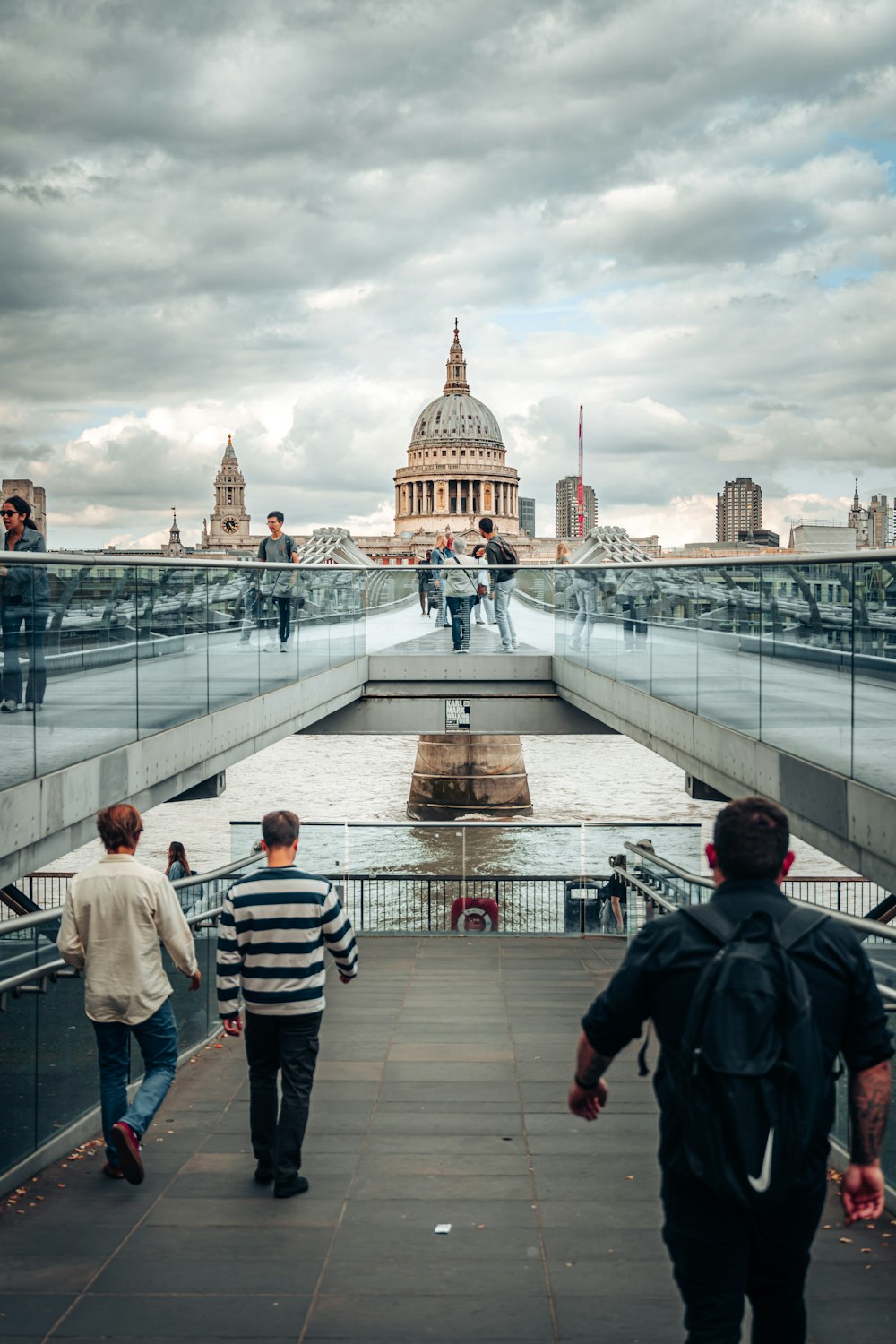 a group of people walking across a bridge