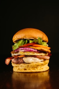 a hamburger with bacon, lettuce, tomato, and cheese