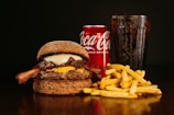 A fast food combo with crispy fries, juicy burger, and a cold drink on a bright background.