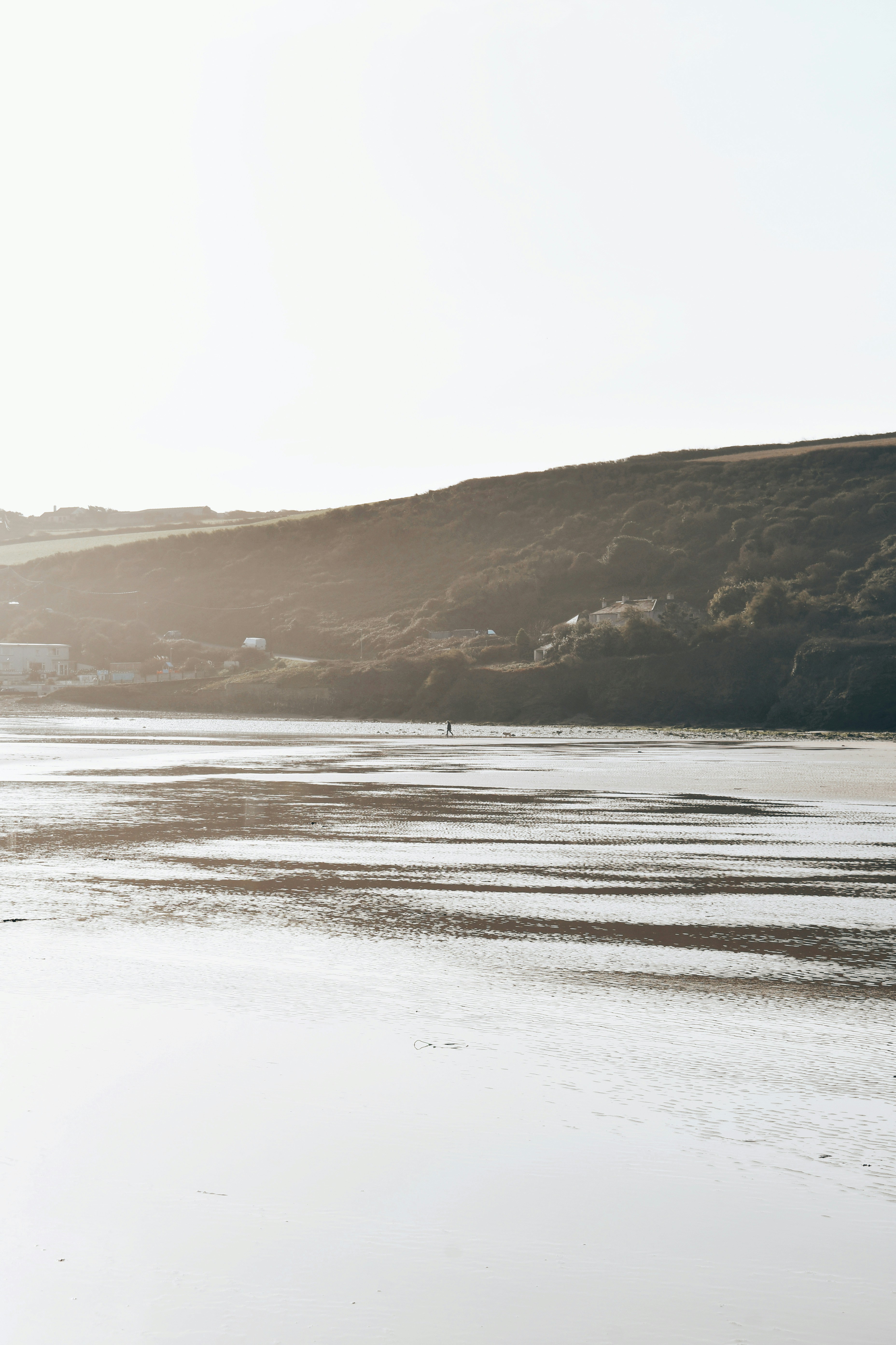 a person walking on a beach with a surfboard