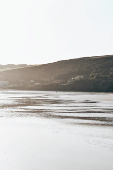 a person walking on a beach with a surfboard
