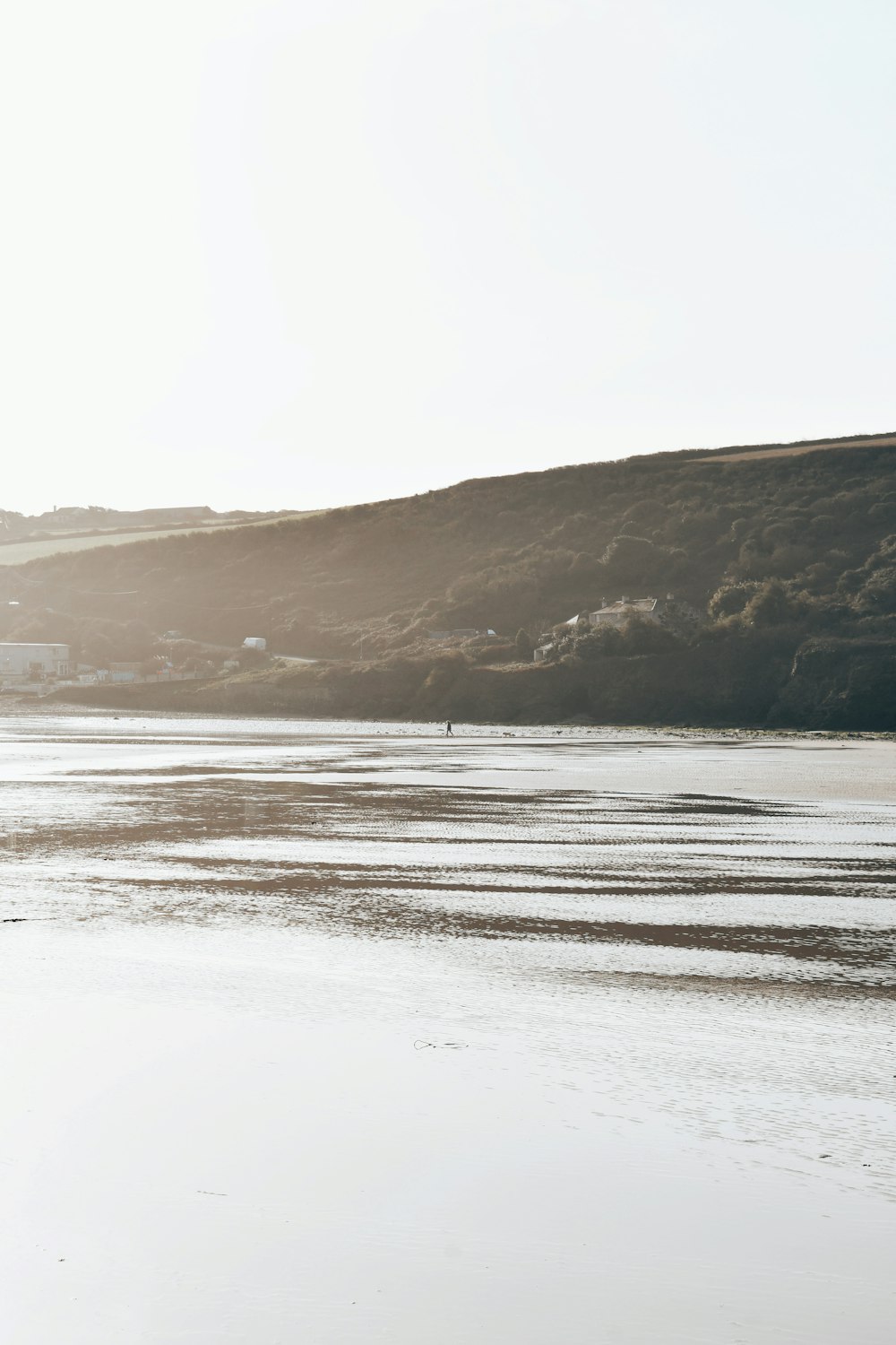 a person walking on a beach with a surfboard