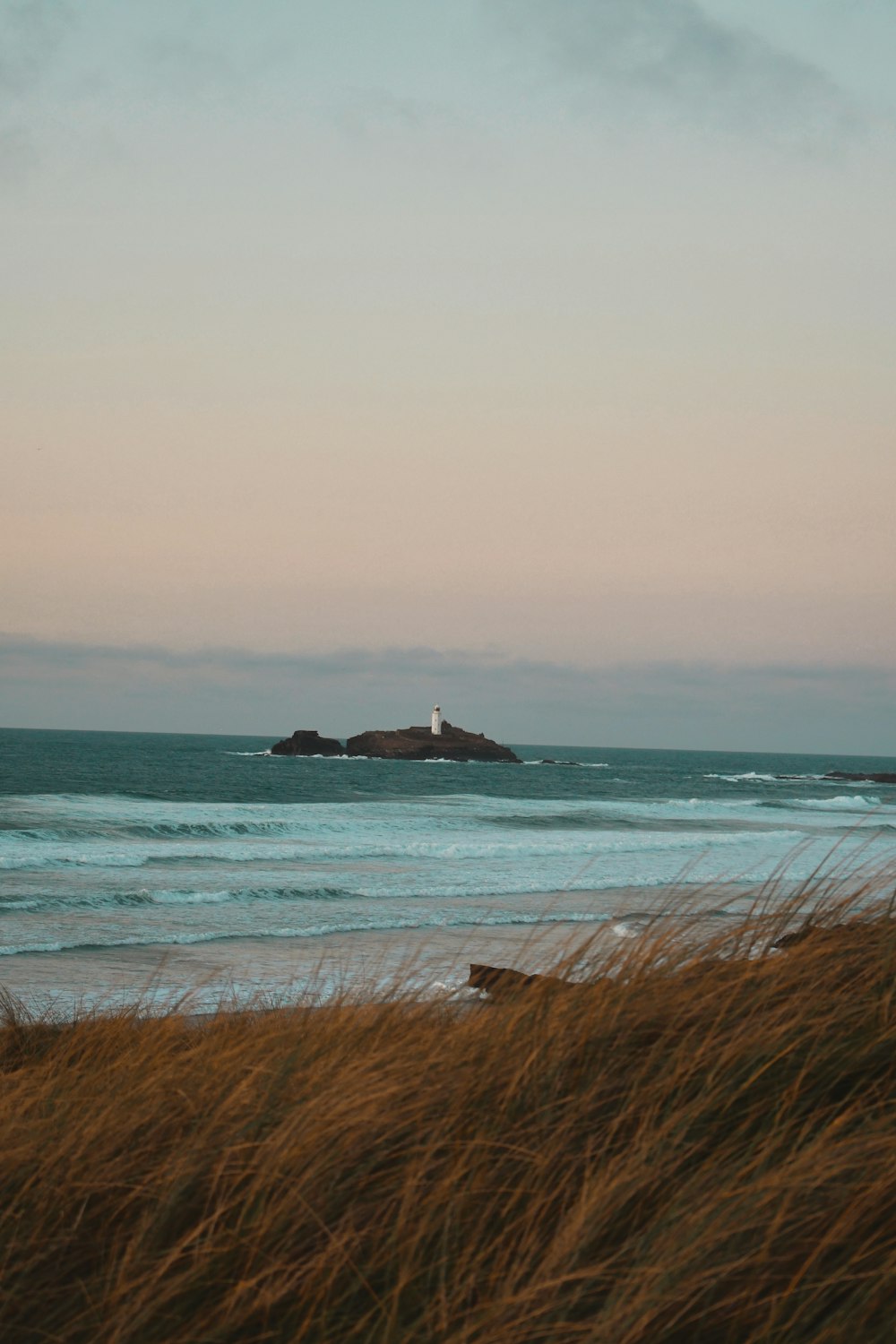 a view of the ocean with a lighthouse in the distance