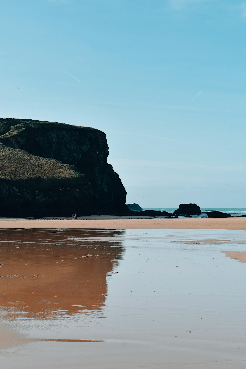 a person walking on a beach next to the ocean