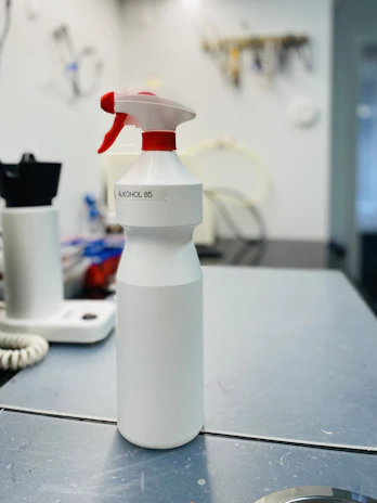 Industrial workspace with sleek white and steel surfaces, featuring a bottle of MEKP-9 Norox prominently displayed.