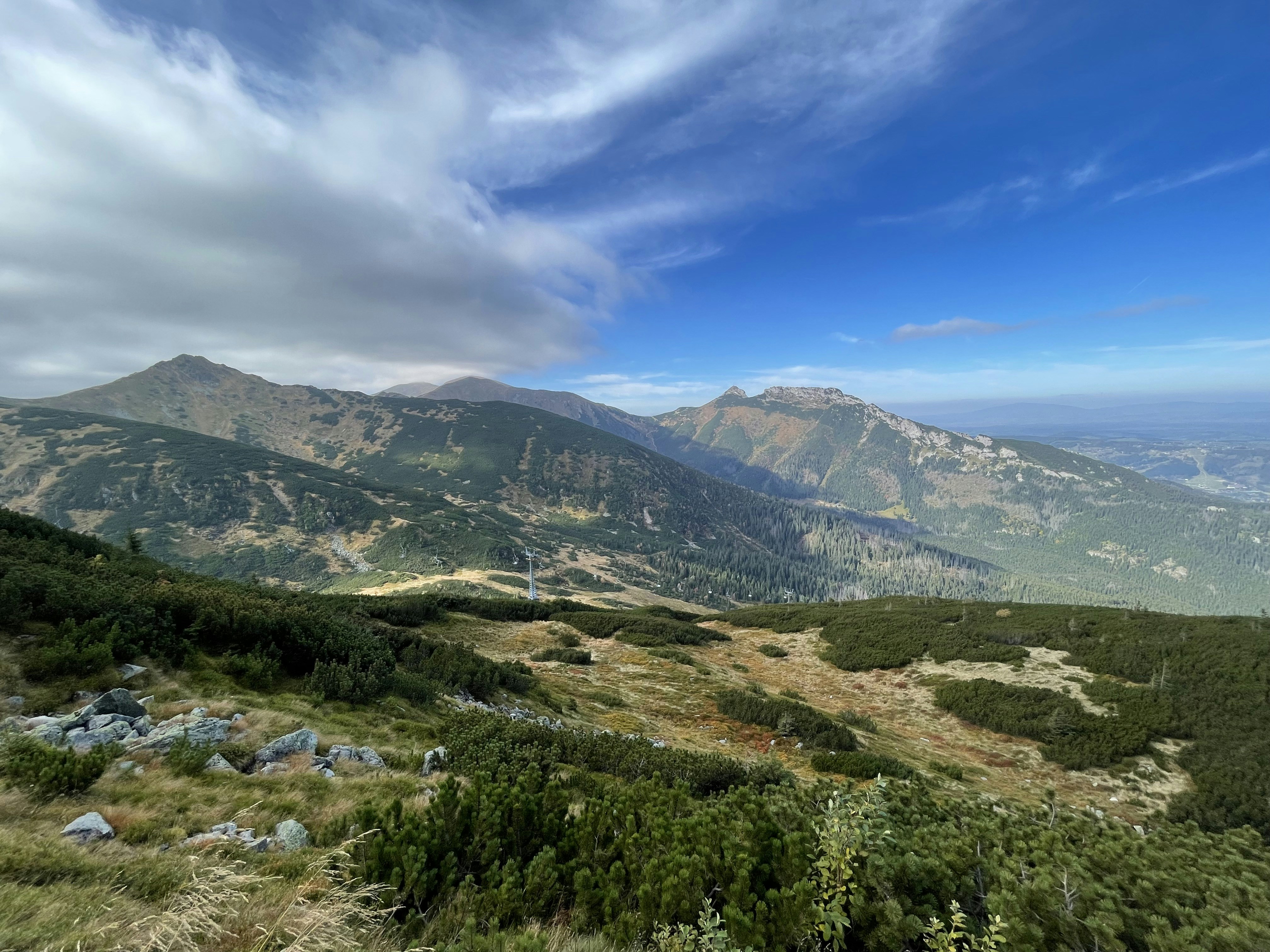 a scenic view of a mountain range with a blue sky
