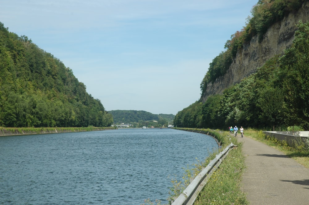 a man riding a bike down a road next to a river