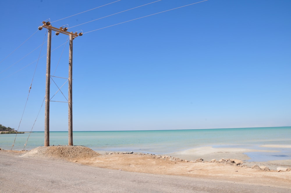 a telephone pole sitting on the side of a road next to the ocean