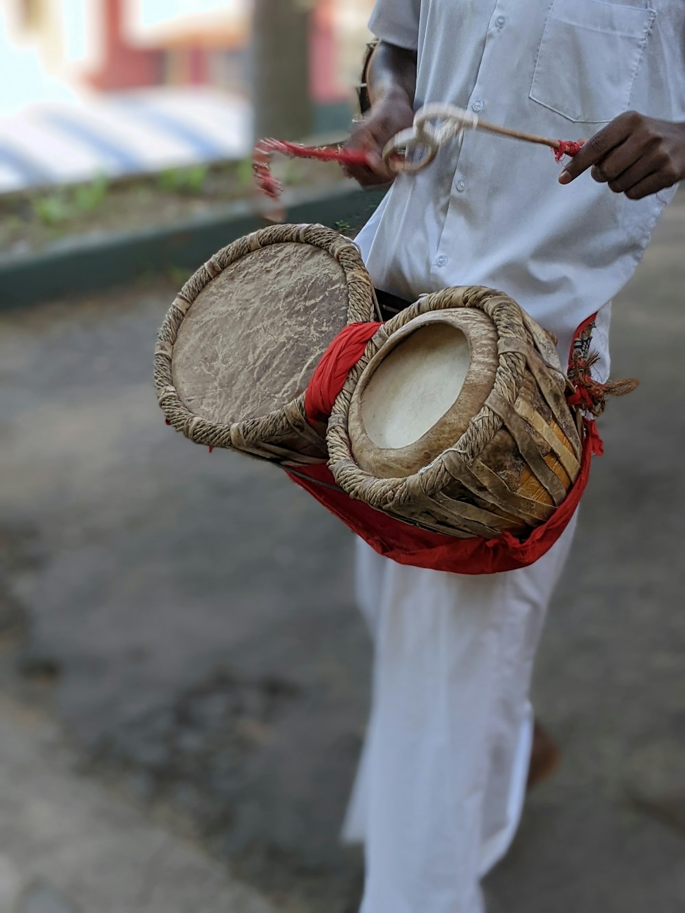 a man holding a basket and two drums