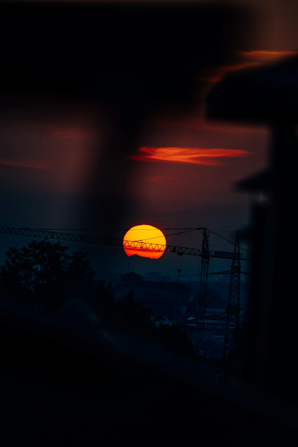 the sun is setting over a city with power lines