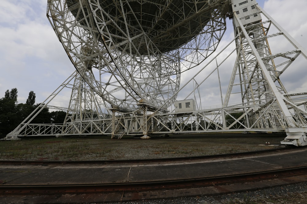 a large metal structure sitting on top of a lush green field