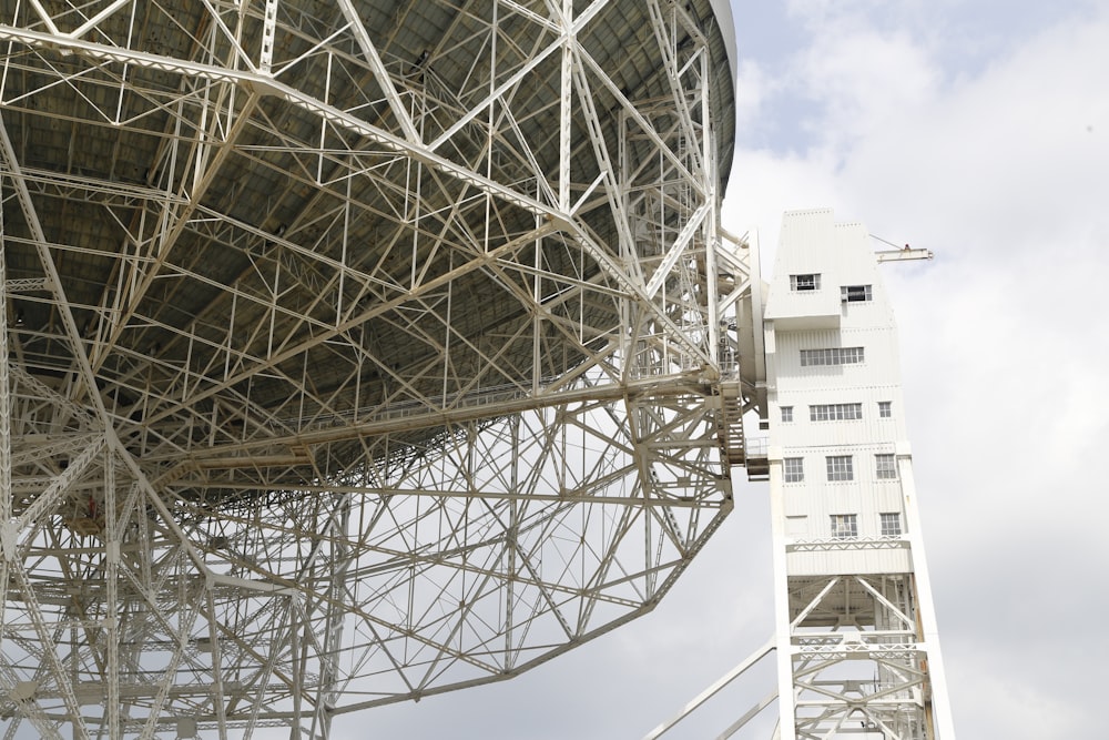 a large metal structure sitting next to a tall building