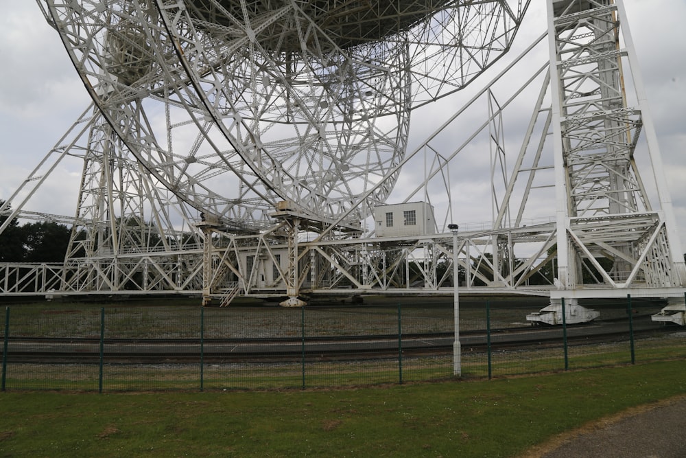 a large metal structure sitting on top of a lush green field