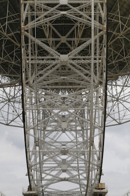 Technician inspecting a large metal structure with measuring instruments