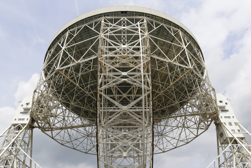 a large metal structure sitting under a cloudy blue sky